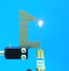 NFB-FHJ flame height jig positioned next to a lit needle flame burner to calibrate a precise 12 mm flame height