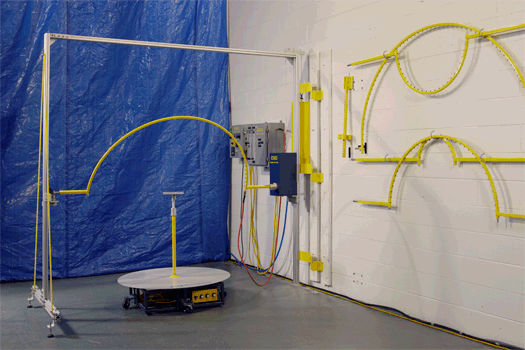 Model OTU Oscillating Spray Tester with a yellow oscillating tube and motorized specimen turntable for IPX3 and IPX4 testing.